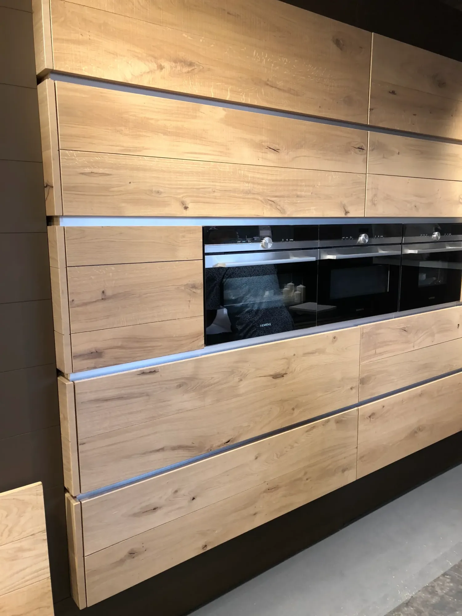 Fours encastrés dans les façades en bois d’une cuisine du showroom