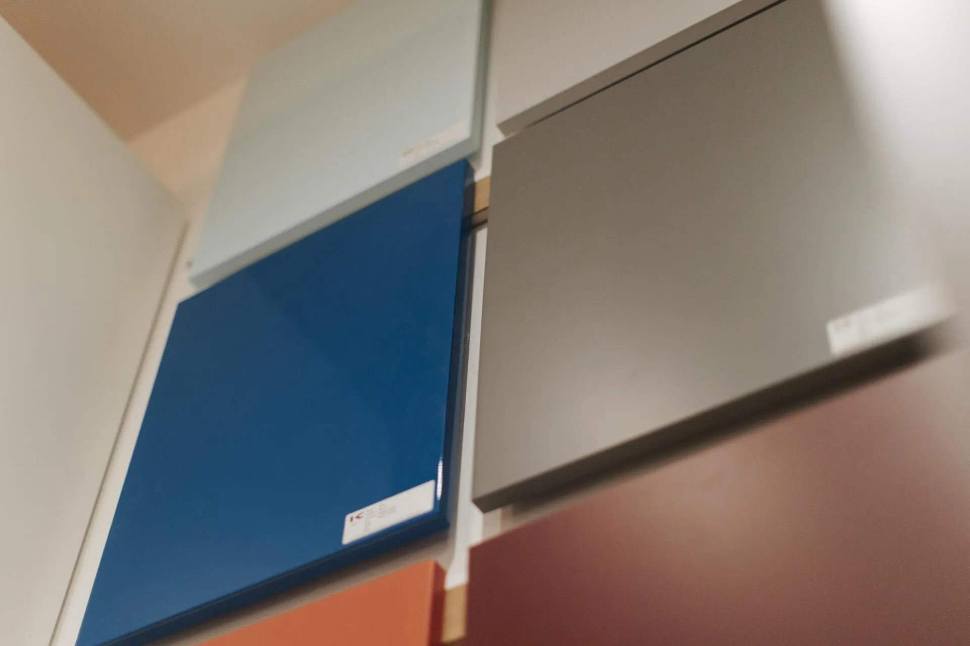 Échantillons de finitions bleues, grises et rosées présentés au showroom